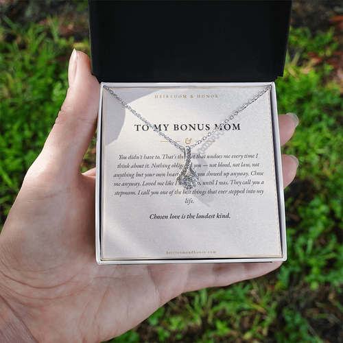 Hand holding gift box with To My Bonus Mom message card and alluring beauty necklace