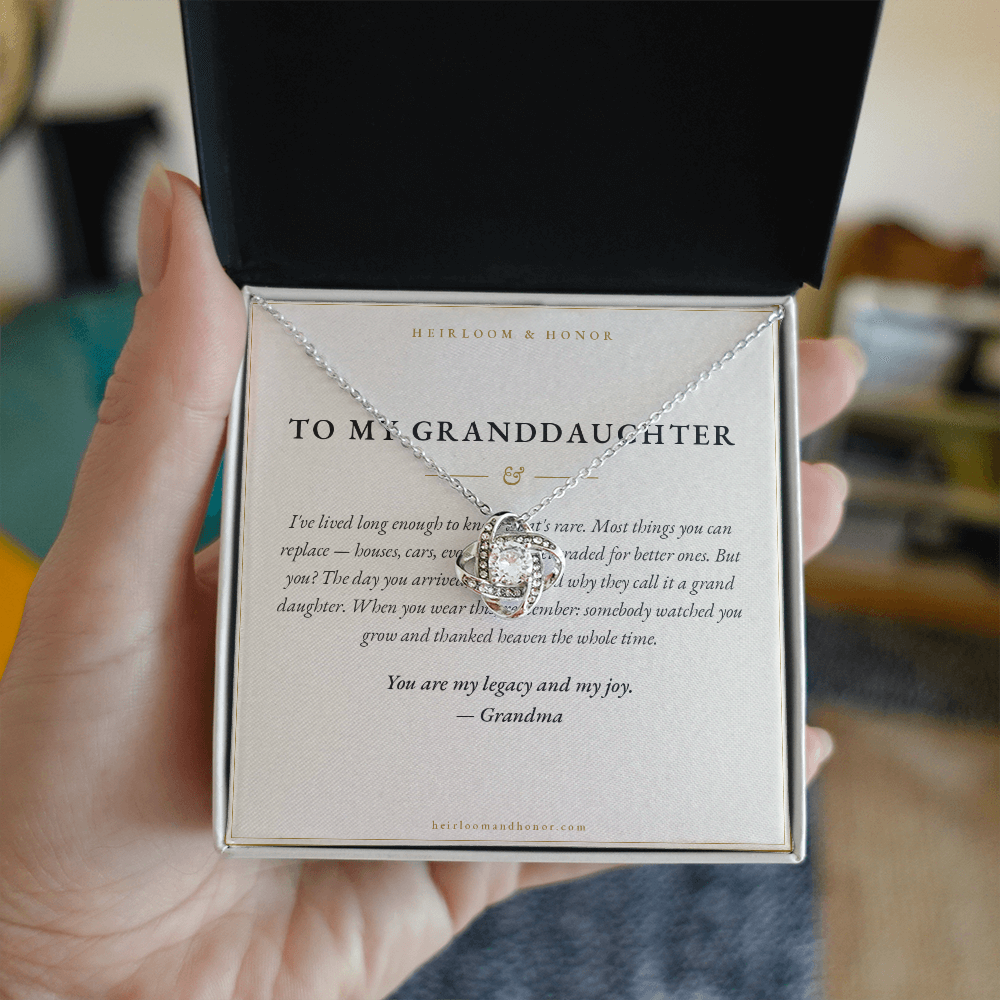 Hand holding open gift box with To My Granddaughter message card and love knot necklace