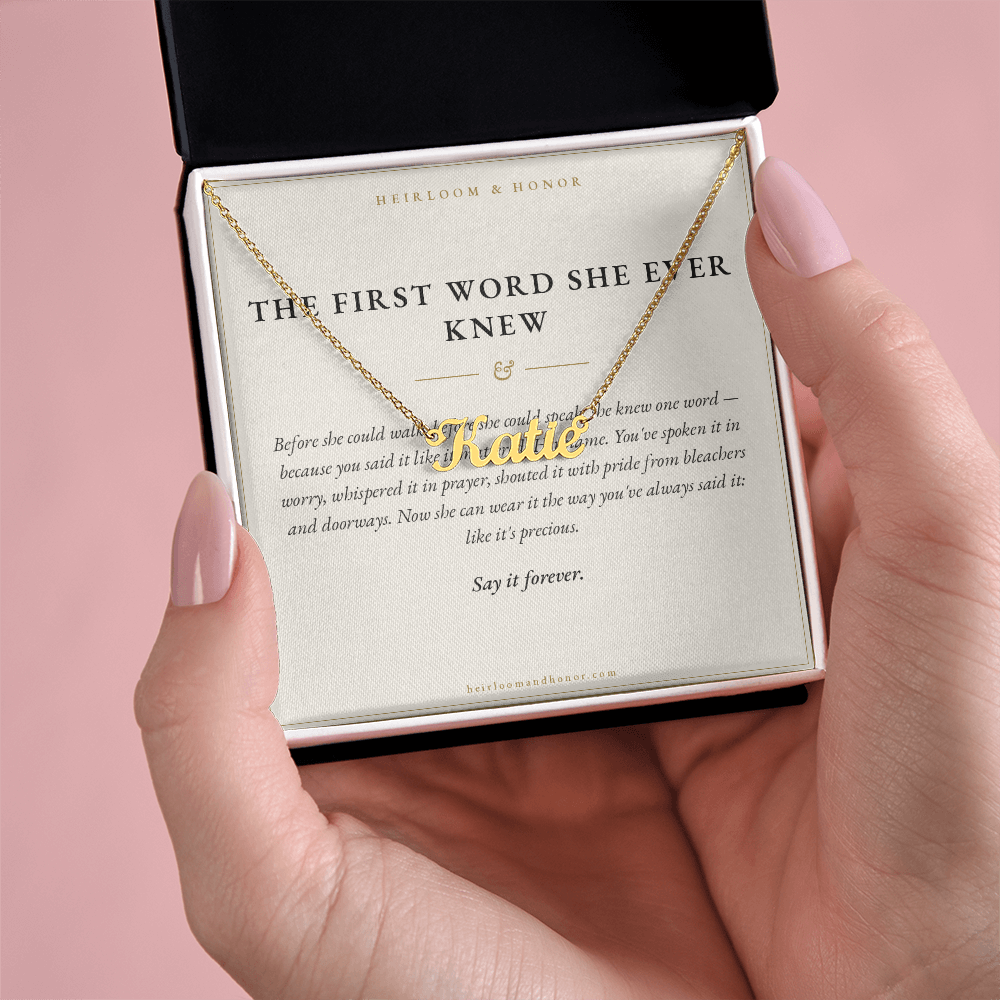 Hand holding gift box with 18k gold Katie custom name necklace and message card