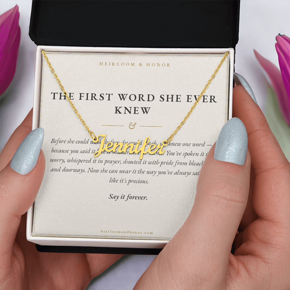 Hands opening gift box with gold Jennifer name necklace on message card